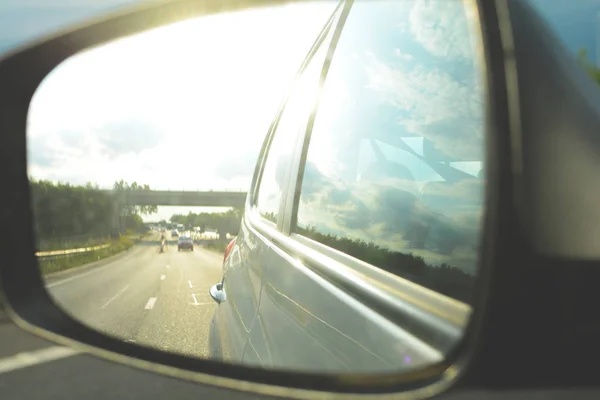 Kijken in de vleugel spiegel tijdens het rijden in een auto — Stockfoto