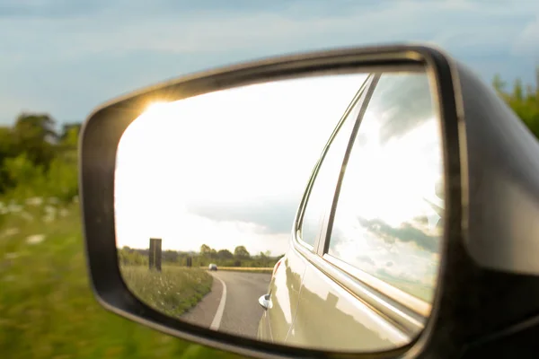 Kijken in de vleugel spiegel tijdens het rijden in een auto — Stockfoto