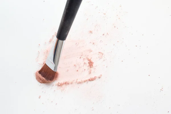 Maquiagem escova na superfície branca, maquiagem cosmética em pó explodindo — Fotografia de Stock