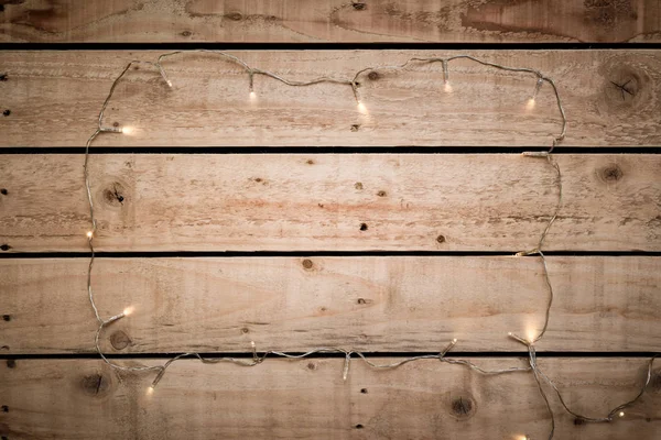 Fairy lights arranged in a frame shape over natural wooden floor