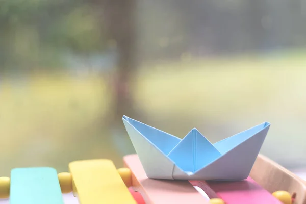 Origami boat by a window on a rainy day inside the house
