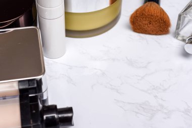 Ma üzerinde fırça ve parfüm şişesi ile makyaj ve kozmetik ürünleri