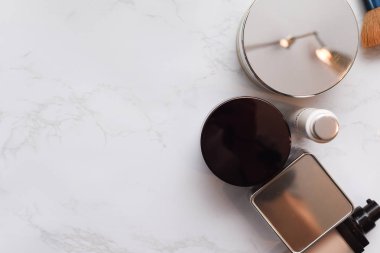 Ma üzerinde fırça ve parfüm şişesi ile makyaj ve kozmetik ürünleri