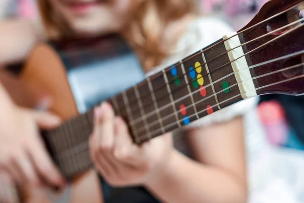 女孩学习弹吉他在音乐课上关于教学 — 图库照片