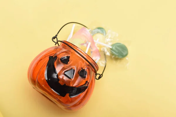 Astuce ou traiter la citrouille pleine de bonbons d'Halloween et de bonbons sur le yel — Photo