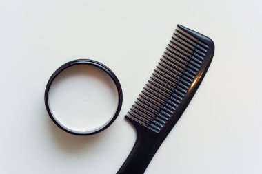 Beyaz arka planda siyah taraklı erkek saç macunu