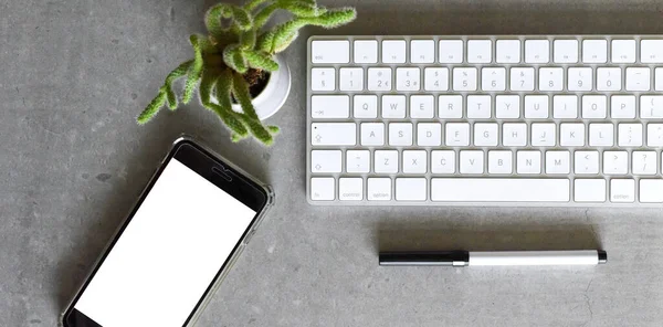 Modern office desk from top view with keyboard phone and pen