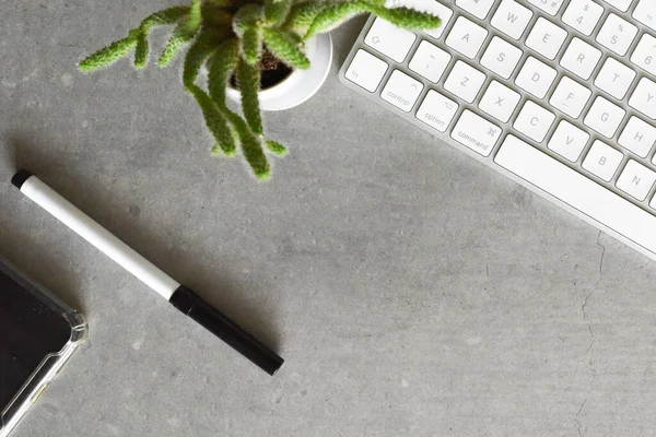 Modern office desk from top view with keyboard phone and pen