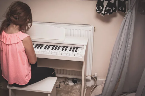 Girl Learning To Play Piano At Home On Elctric Piano In The Bedroom Stock Images Page Everypixel