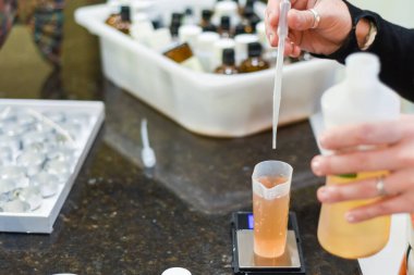 Ev yapımı kokulu mumlar yapmak için gerekli yağları ölçüyorum.