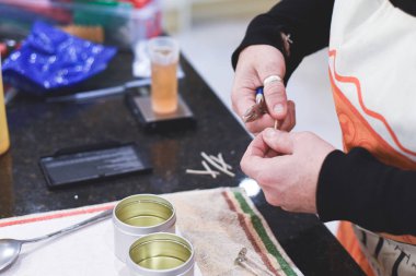 Chandler veya mum imalatçısı kokulu el yapımı mumlara fitil ekler.