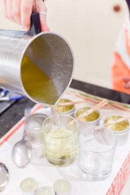 Kavanozlara sıvı balmumu döküldüğünü gösteren yaratıcı bir meşgale.