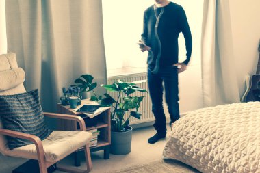 Evde çalışan bir adam toplantı sırasında telefonla konuşuyor.