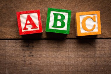 Renkli ahşap mektup blok üzerinde kahverengi ahşap arka plan yapma