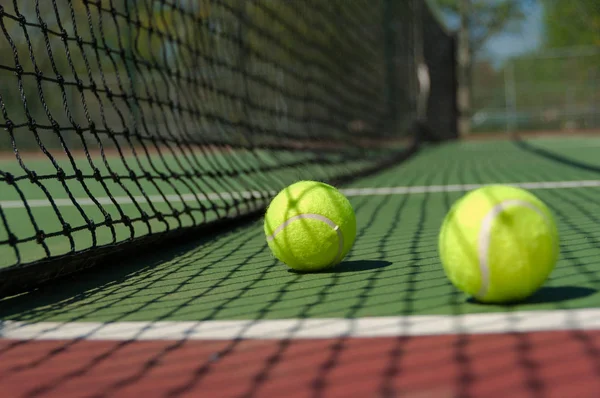 Green, Yellow Tennis balls on tennis court Royalty Free Stock Images