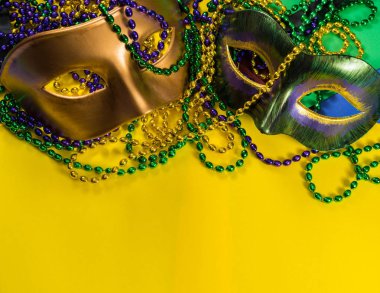 Mardi Gras maskesi ile sarı bir arka plan üzerine boncuk