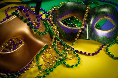 Mardi Gras maskesi ile sarı bir arka plan üzerine boncuk