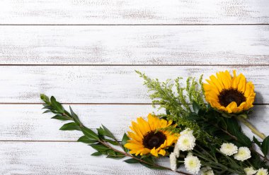 Beyaz ahşap arkaplanda, kopyalama alanı olan sarı ayçiçeği düzeneği