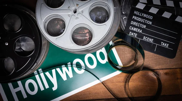 Film reel and clapboard. Hollywood, entertainment industry background on a wood table