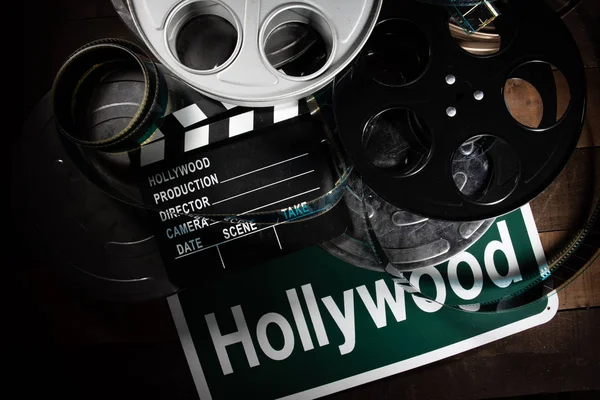Film rulle och clapboard. Hollywood, underhållningsbranschen bakgrund på ett träbord — Stockfoto