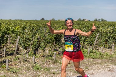 39. Medoc Maratonu sırasında üzüm bağlarının önünde kostümlü bir koşucu.