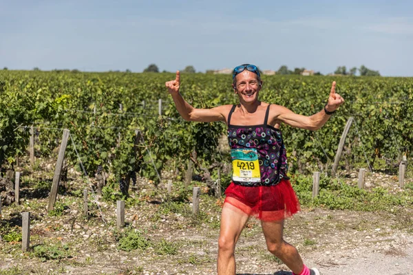 39. Medoc Maratonu sırasında üzüm bağlarının önünde kostümlü bir koşucu.