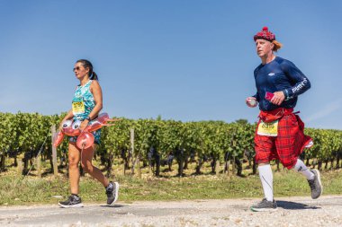 39. Medoc Maratonu sırasında üzüm bağlarının önünde kostümlü koşucular.