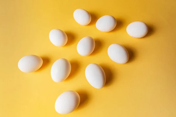 Minimalism style. Food concept. An image of eggs pattern over yellow pastel background.