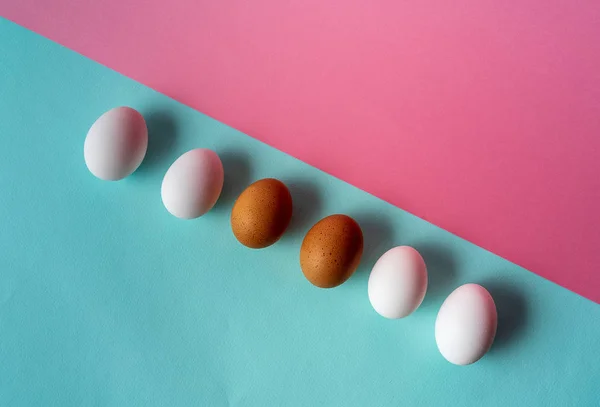 Eggs pattern over aqua and pink pastel background.