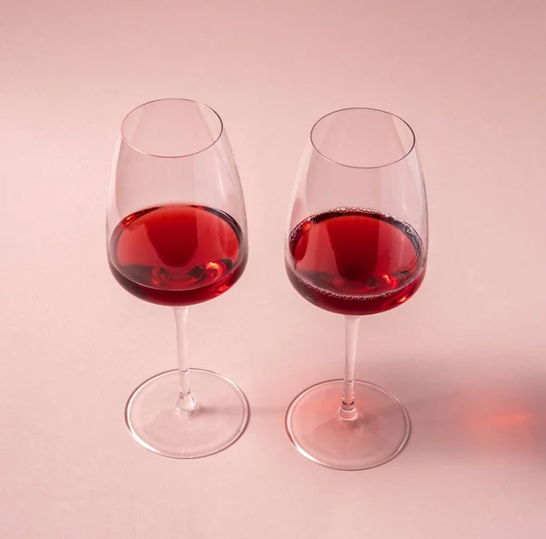 Glasses of red wine on pink background,top view.