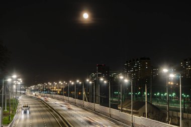 The moon rising over the illuminated highway and the night city, clipart