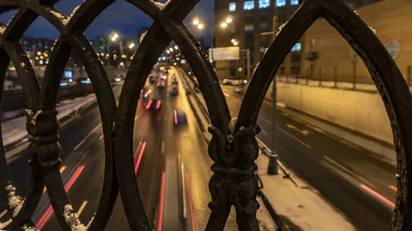 Снимок ночного движения, сделанный через чугунный забор — стоковое фото