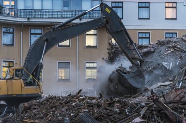 binanın enkazı üzerinde çalışan ekskavatör,