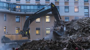 binanın enkazı üzerinde çalışan ekskavatör,