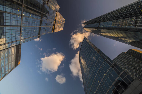 Bottom-up view of skyscrapers and flying clouds