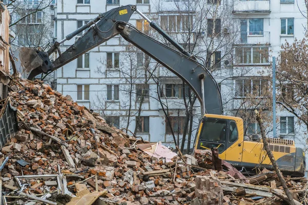 binanın enkazı üzerinde çalışan ekskavatör,