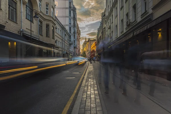 人的剪影，和汽车在城市街道上日落 免版税图库图片