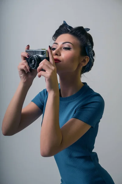 Sexy girl in pin-up style makes the photo on the retro camera Stock Image