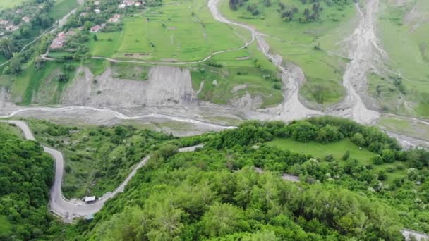 Photographie aérienne. Collines verdoyantes, montagnes et une allée, une vue d'une hauteur. 4K 
