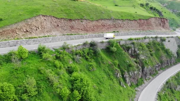 Eine Auffahrt, die von grünen Hügeln aus der Vogelperspektive umgeben ist. 4k — Stockvideo