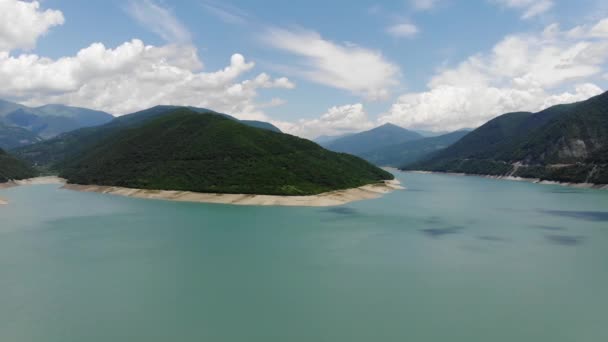 Fotografía aérea de una laguna azul rodeada de verdes colinas, un hermoso cielo despejado. 4k — Vídeo de stock