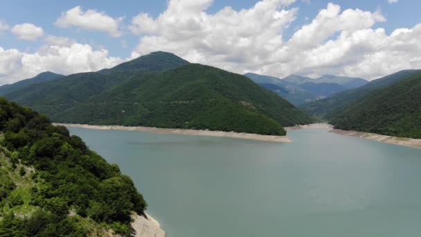 Fotografía aérea de una laguna azul rodeada de verdes colinas, un hermoso cielo despejado. 4k — Vídeo de stock