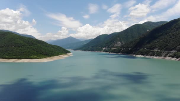 Fotografia aérea de uma lagoa azul cercada por colinas verdes, um belo céu limpo. 4k — Vídeo de Stock