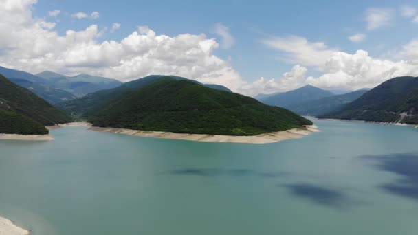 Fotografia aérea de uma lagoa azul cercada por colinas verdes, um belo céu limpo. 4k — Vídeo de Stock