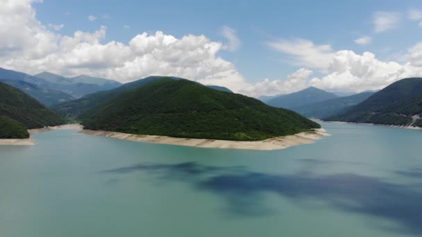 Fotografía aérea de una laguna azul rodeada de verdes colinas, un hermoso cielo despejado. 4k — Vídeo de stock