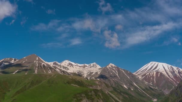 El movimiento de las nubes sobre los picos nevados de las verdes montañas. 4k. Caducidad — Vídeos de Stock