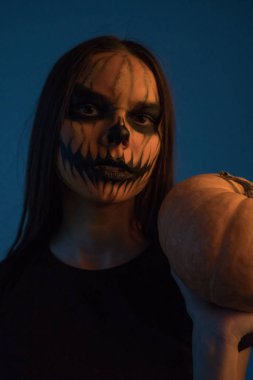 Bir ölü bir kız bir kabak koyu arka plan üzerinde maskeyle mans. Cadılar Bayramı