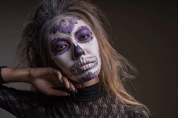 Porträtt av en flicka med en målad mask av en död person på hennes ansikte, isolerad på en mörk bakgrund. Halloween semester — Stockfoto