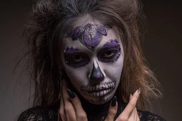 Portret van een meisje met een geschilderde masker van een dode persoon op haar gezicht. Halloween vakantie — Stockfoto