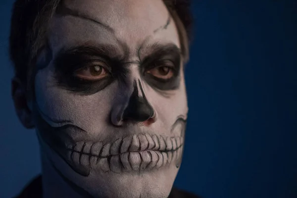 Porträtt av en ung man med en skalle makeup till Halloween på svart bakgrund — Stockfoto